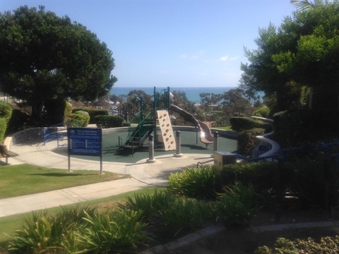 Sea View Park with a playground and climbing structure, surrounded by greenery and ocean views.